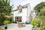 Evolution Storm Windows in cream complimentd with a three part bi fold door leading into the garden